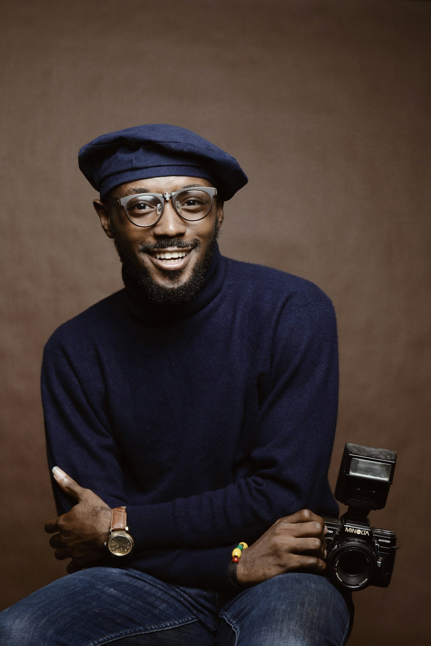 A smiling man in a navy sweater, seated for a portrait